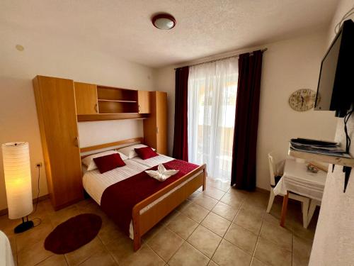 a bedroom with a bed and a window and a television at Villa Marina Bol in Bol