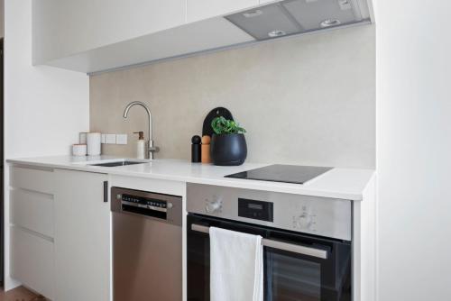 una cocina con fregadero y estufa en Stylish Stay on Courtenay - 1BR APT, en Wellington