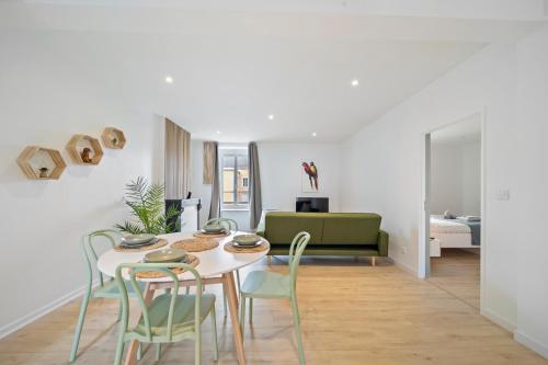 une salle à manger blanche avec une table et des chaises dans l'établissement Lion King Appart 65 m2 tout inclus, à Chalon-sur-Saône