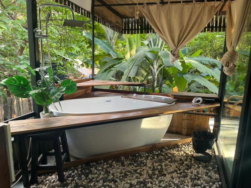 a bath tub in a room with plants at Missme Homestay-มิสมีโฮมสเตย์ in Ban Mae Na