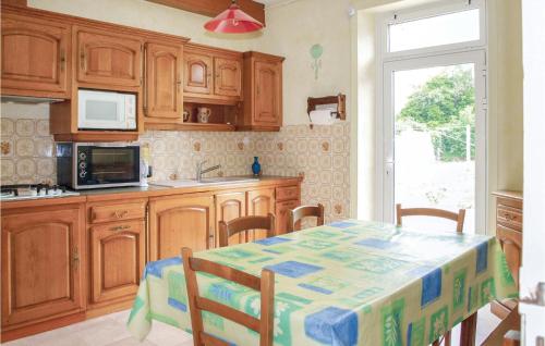 a kitchen with wooden cabinets and a table with a microwave at Holiday Home Hent Gwaz Ar Gouez in Locquémeau