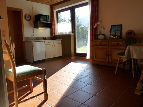 a kitchen with a chair and a table and a window at Ferienhaus Schäfer - Apartments - Wintersports - Family holiday - Holiday with your dog - Rural & Scenic in Flattnitz