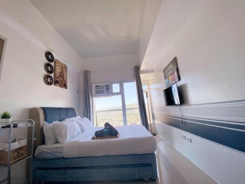 a small bedroom with a bed and a window at Twilight23 Condo in Cebu City