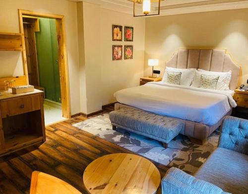 a hotel room with a large bed and a couch at Echor Mandara TreeVilla Dharamshala in Dharamshala