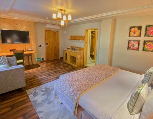 a bedroom with a large white bed and a desk at Echor Mandara TreeVilla Dharamshala in Dharamshala
