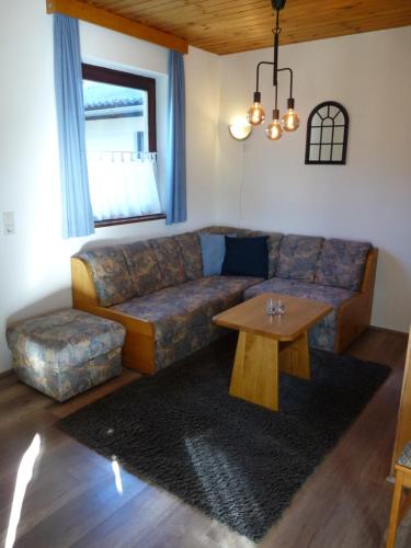 a living room with a couch and a table at Ferienhaus Schäfer - Apartments - Wintersports - Family holiday - Holiday with your dog - Rural & Scenic in Flattnitz