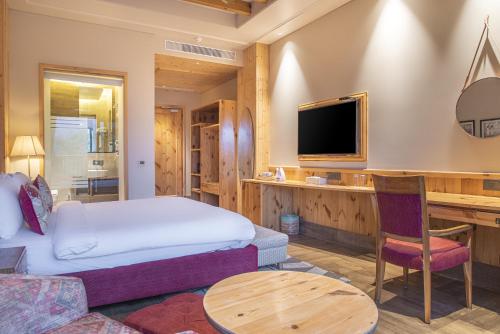 a hotel room with a bed and a desk at Echor Mandara TreeVilla Dharamshala in Dharamshala