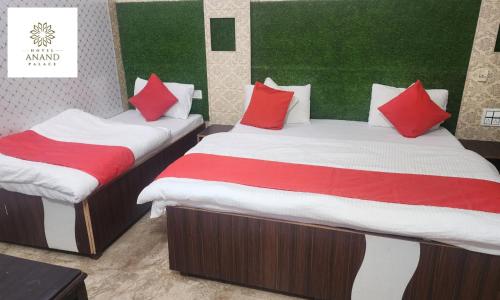 two beds in a room with red and white pillows at Hotel Anand Palace in Jawāla Mukhi