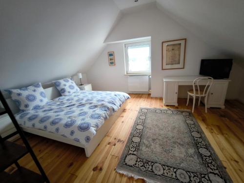 Un dormitorio con una cama y un escritorio y una ventana. en Haus Rosalinde, en Klüsserath