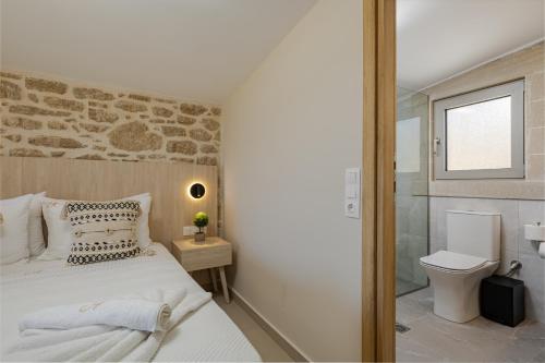 a bedroom with a bed and a toilet and a window at Alki Villas Collection -Luxury Sea View Villas -Breakfast Included-Falasarna in Falasarna