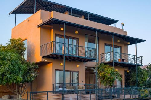 a building with balconies on the side of it at ELIVAAS Cows & Cuddles 4 BHK with Pvt Pool and Garden in Debāri