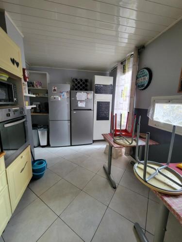 a kitchen with two refrigerators and a table and chairs at appartement 3 chambres, idéal pour déplacement in Échirolles