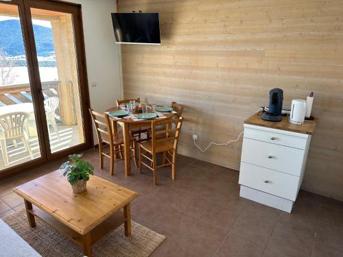 une salle à manger avec une table, des chaises et une télévision dans l'établissement Appart T2 Cosy vue panoramique Lac & Montagnes, aux Angles