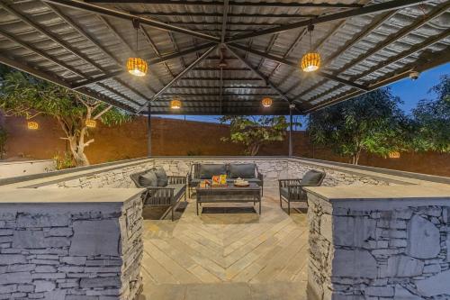 DebāriELIVAAS Cows & Cuddles 4 BHK with Pvt Pool and Garden的凉亭下有桌椅的露台