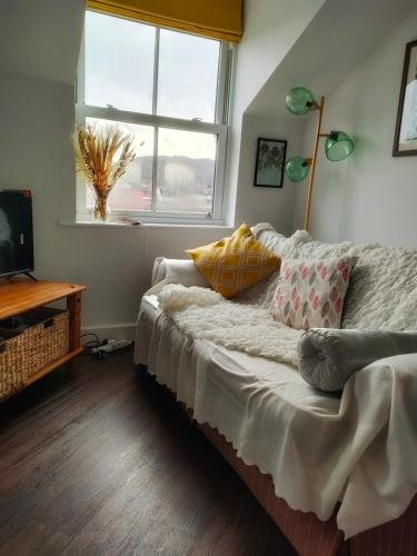 a bedroom with a bed with pillows and a window at Cosy flat in central Wellington in Telford