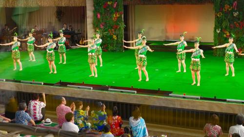 a group of women dancing on a green stage at Taira View Hotel in Iwaki