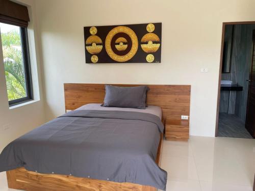 a bed in a bedroom with a picture on the wall at Mirari Villa in Koh Phangan