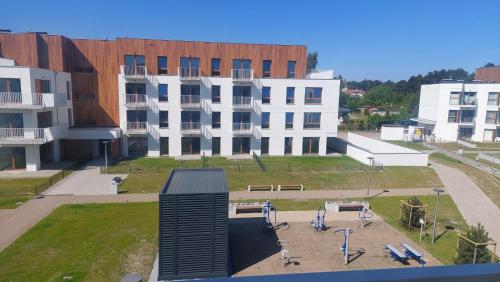a view of a building with a skate park in front at APARTAMENT BALTICHOFF FUN with Sea View, Basen, Spa, Gym, Sauna, Hala sportowa z kortem tenisowym in Gąski