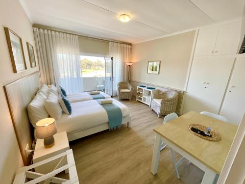 スワコプムントにあるLoewenhof Seaview Suites Unit 7のベッドと机とテーブルのある寝室