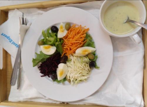 a plate of food with eggs and vegetables and a bowl of soup at Residence MaryHouse - Free Breakfast and Taxi From Airport in Cotonou