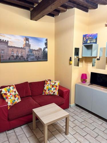 a living room with a red couch and a coffee table at Naviglio 34 in Parma