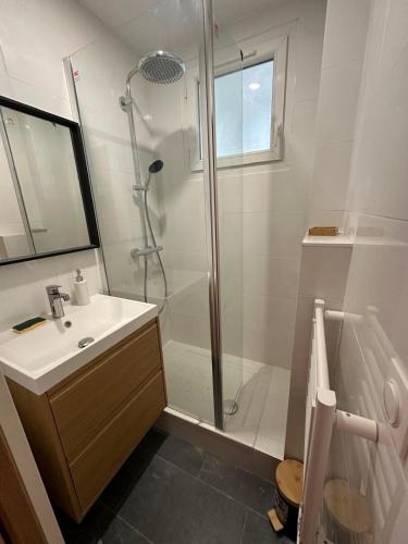 une salle de bain blanche avec une douche et un lavabo dans l'établissement Apartment - 2 rooms - Malakoff, à Malakoff