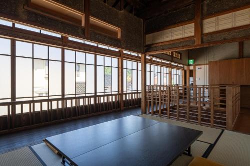a room with a table in a room with windows at 法勝寺温泉 別館 