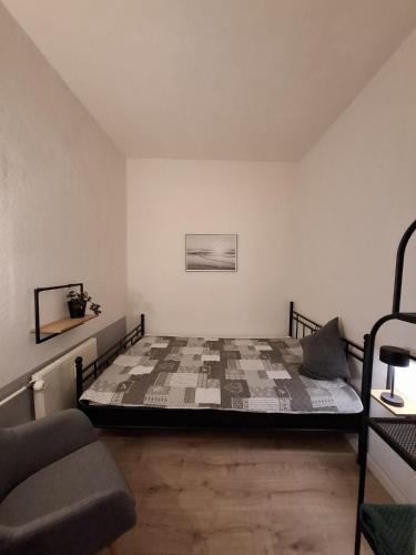 a bedroom with a bed and a chair in it at Ferienwohnung Meeresglück in Kruså