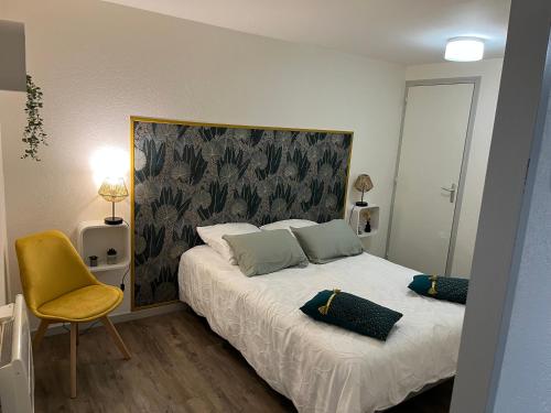 - une chambre avec un lit et une chaise jaune dans l'établissement Le cosy du marché Notre-Dame, à Poitiers