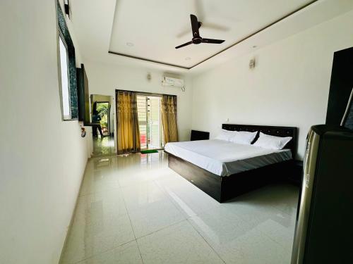 a bedroom with a bed and a ceiling fan at kokan kinara by wild flower in Pune