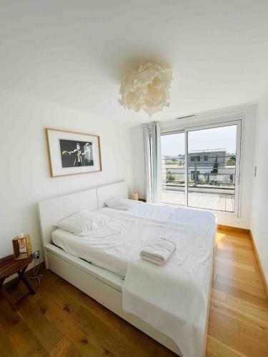 une chambre blanche avec un lit et une fenêtre dans l'établissement Beautiful new house near beach and train station, à La Baule