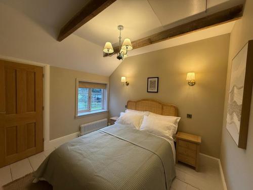 a bedroom with a large bed and a window at Rose Cottage, Luxury cottage, sleeps 16 in South Raynham