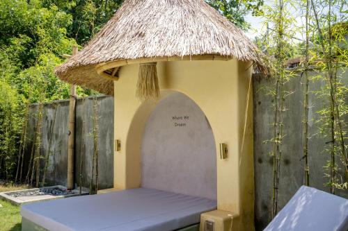 a small hut with a bench in a yard at Mimpi Tropis in Badung