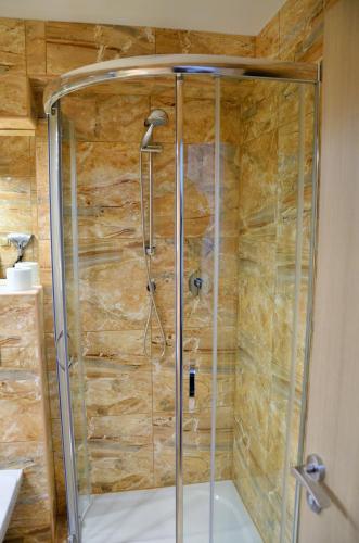 a shower with a glass door in a bathroom at Hotelový resort Šikland in Zvole