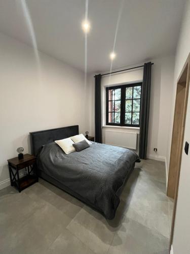 un dormitorio con una cama y una ventana en Neighbourhood Apartment, en Lublin