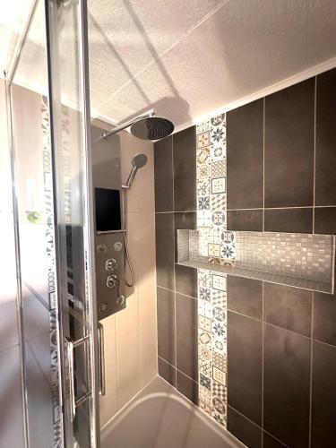 La salle de bains est pourvue d'une douche et d'une baignoire. dans l'établissement Hébergement Privé à Larnod, à Larnod