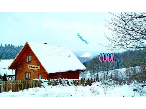 a red barn in the snow with a fence at W dolinie Sanu in Lesko