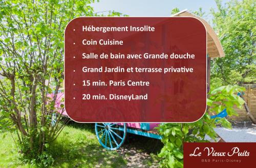 un panneau en face d'un jardin avec un arbre dans l'établissement Roulotte Insolite avec terrasse proche Paris, à Noisy-le-Grand