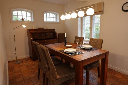 Un comedor con mesa y sillas de madera. en Min aran, en Oevenum