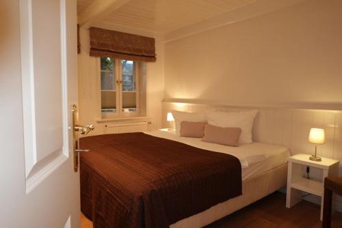 Un dormitorio con una cama con dos almohadas y una ventana. en Min aran, en Oevenum