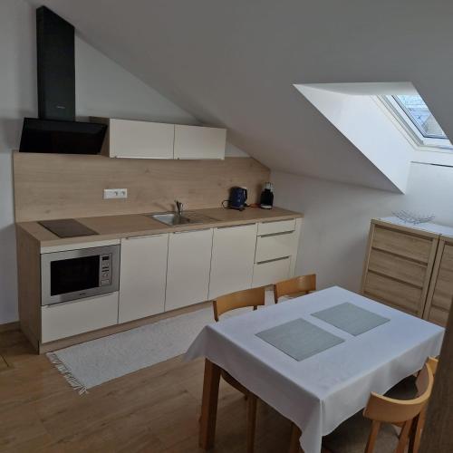 a kitchen with a sink and a table with chairs at Žiar Apartmány 43 in Žiar