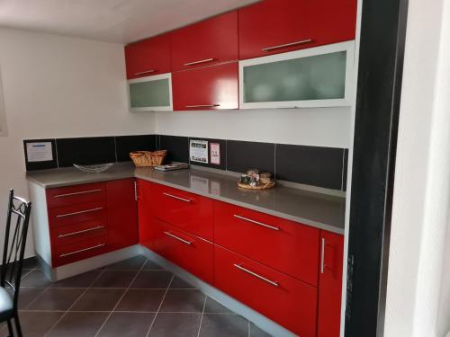 a kitchen with red cabinets and gray counter tops at L occitane in Gimont