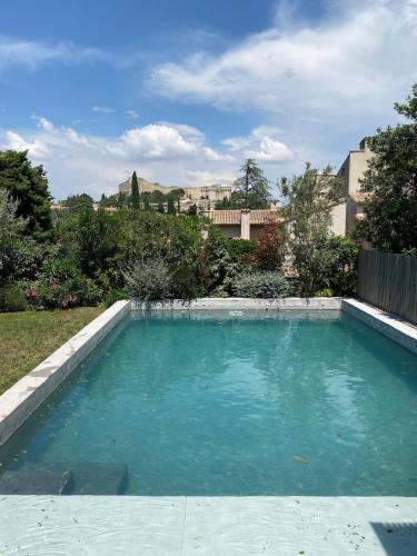 une piscine avec de l'eau bleue dans une cour dans l'établissement Près d'Avignon maison luxe vue terrasses piscine, à Villeneuve-lès-Avignon
