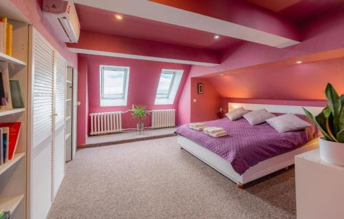 a bedroom with pink walls and a bed with purple sheets at Awesome Apartment In Nowe Warpno in Nowe Warpno
