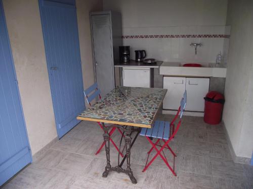 una pequeña cocina con mesa y 2 sillas en La Roulotte des Amis en Ousson-sur-Loire