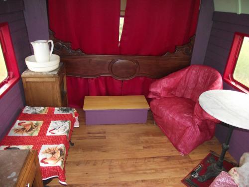 a small room with a red curtain and a couch at La Roulotte des Amis in Ousson-sur-Loire