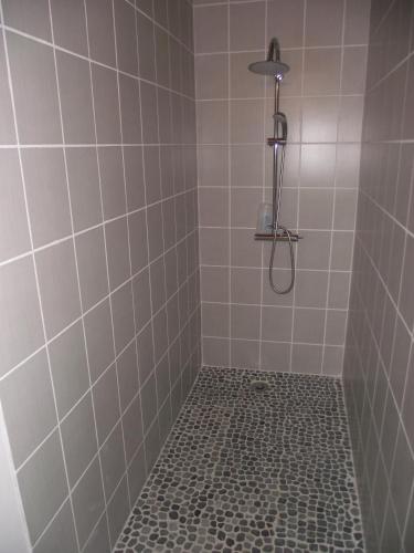 y baño con ducha y suelo de baldosa. en La Roulotte des Amis en Ousson-sur-Loire