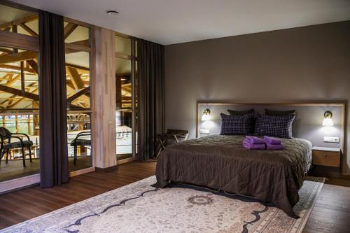 a bedroom with a large bed with purple pillows at Royal Horse Resort in Balkasodis