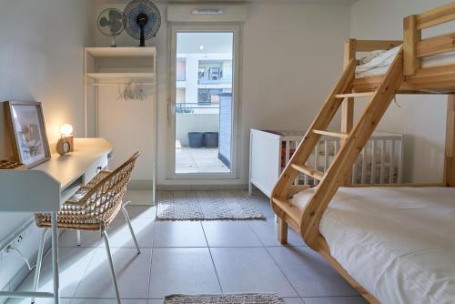 - une chambre avec des lits superposés, un bureau et une chaise dans l'établissement Belle Escale - T3 cosy avec grande terrasse, à Toulon