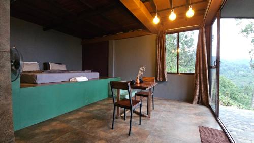 a room with a bed and a table and chairs at The Backyard Balangoda in Balangoda